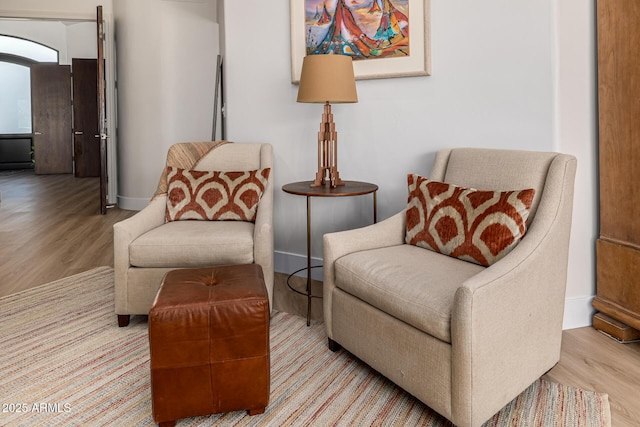 sitting room with baseboards and wood finished floors