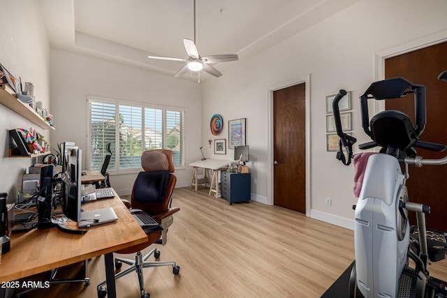 office with a raised ceiling, ceiling fan, light wood-style flooring, and baseboards