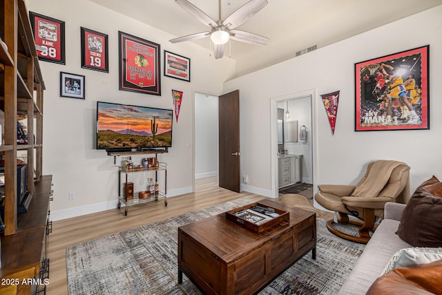 living room with baseboards, ceiling fan, visible vents, and wood finished floors