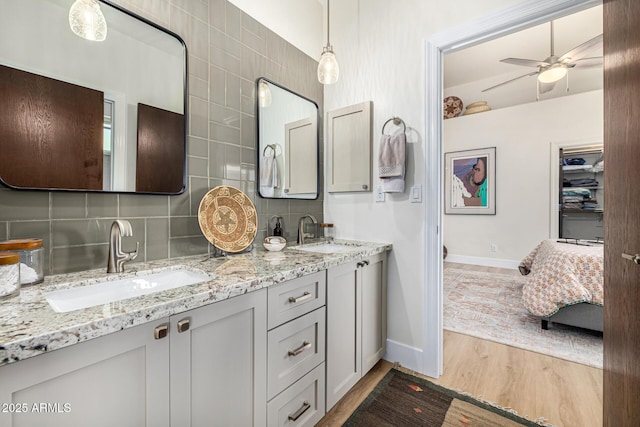 bathroom featuring wood finished floors, tasteful backsplash, and a sink