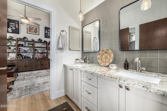 full bath with tasteful backsplash, a sink, and wood finished floors