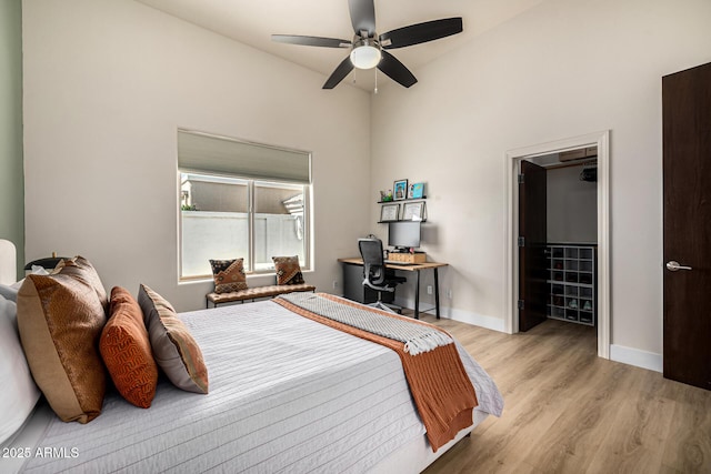 bedroom with a ceiling fan, light wood-style flooring, and baseboards