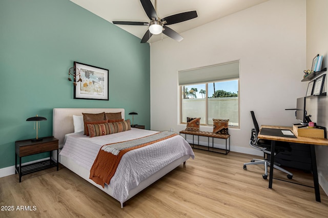 bedroom featuring light wood finished floors, baseboards, and a ceiling fan