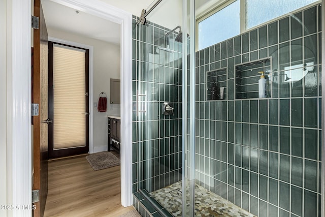 full bath featuring wood finished floors and a shower stall