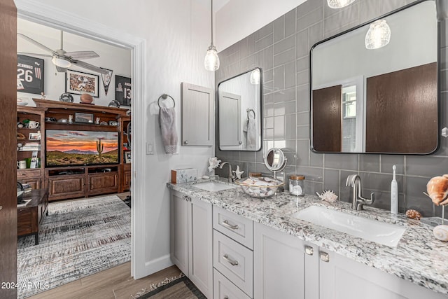 full bathroom with tasteful backsplash, ceiling fan, a sink, and wood finished floors