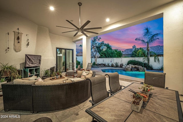 patio terrace at dusk with ceiling fan, fence, an outdoor living space, a fenced in pool, and outdoor dining space