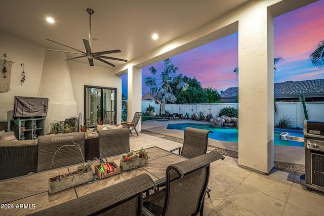 patio terrace at dusk featuring outdoor lounge area, a fenced backyard, ceiling fan, and a fenced in pool