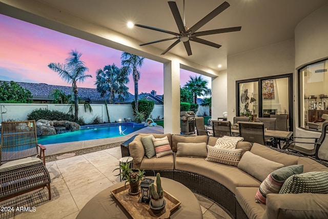 patio terrace at dusk with ceiling fan, a fenced backyard, area for grilling, an outdoor living space, and a fenced in pool