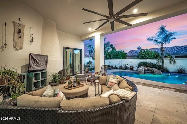 patio terrace at dusk featuring fence, a ceiling fan, an outdoor living space, and a fenced in pool