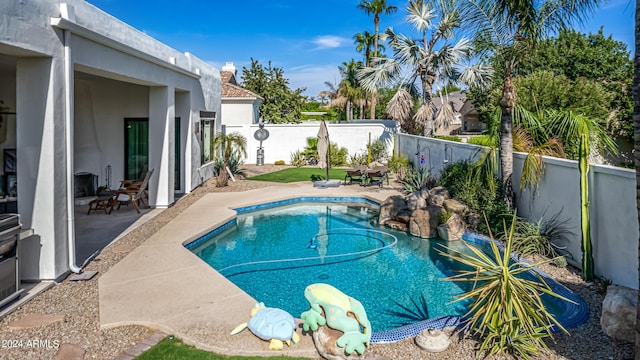 view of swimming pool with a fenced in pool, a fenced backyard, and a patio