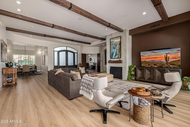 living area featuring light wood finished floors, a fireplace, visible vents, and recessed lighting