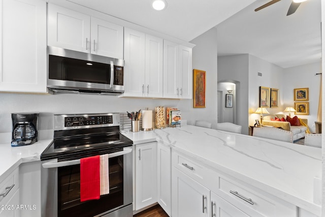 7887 N 16th St Unit 226, Phoenix, AZ 85020 - kitchen with appliances with stainless steel finishes, open floor plan, white cabinetry, arched walkways, and ceiling fan