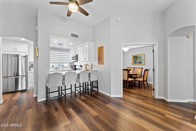 7887 N 16th St Unit 226, Phoenix, AZ 85020 - kitchen with appliances with stainless steel finishes, arched walkways, a breakfast bar area, ceiling fan, and dark wood-style floors