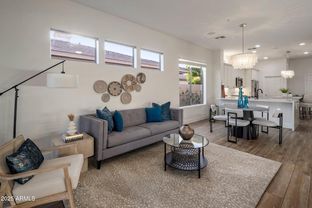 living room featuring a chandelier and wood-type flooring