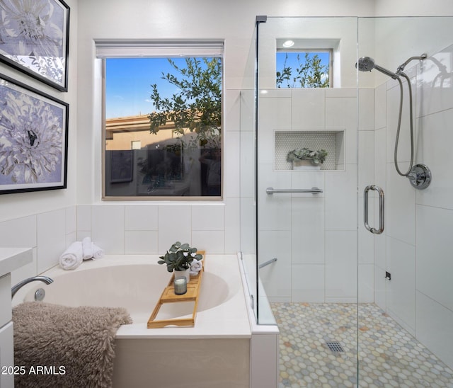 bathroom featuring shower with separate bathtub