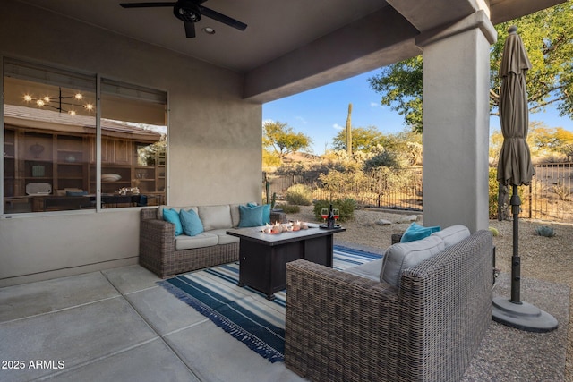 view of patio with ceiling fan and an outdoor living space with a fire pit