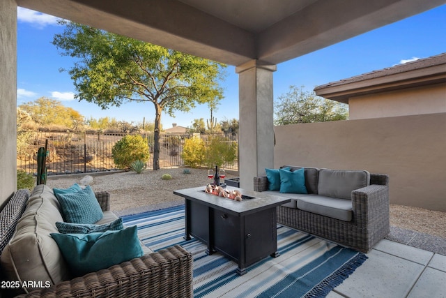 view of patio with an outdoor living space with a fire pit