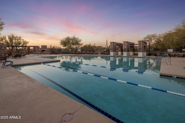 pool at dusk with a patio