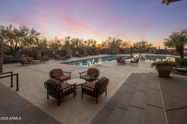 pool at dusk featuring a patio area