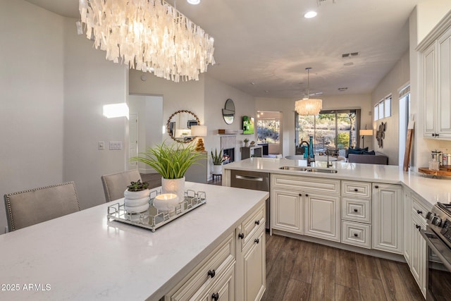 kitchen featuring hanging light fixtures, dark hardwood / wood-style flooring, sink, a notable chandelier, and stainless steel appliances