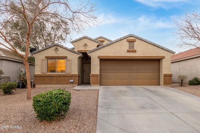 mediterranean / spanish-style house with concrete driveway, a tile roof, an attached garage, and stucco siding