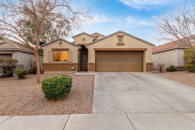 mediterranean / spanish home featuring driveway, an attached garage, a tile roof, and stucco siding