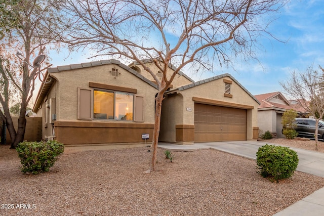 view of front of property with driveway, an attached garage, and stucco siding