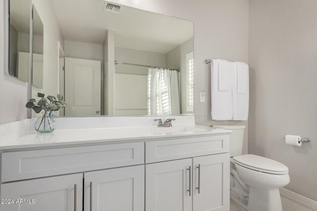 bathroom featuring a shower with curtain, vanity, and toilet