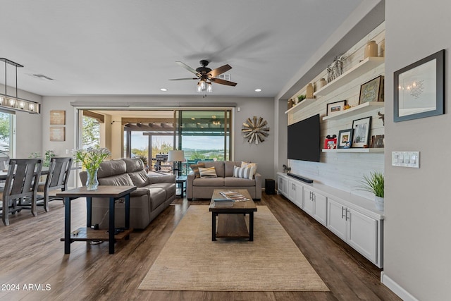 living room with dark wood-type flooring and ceiling fan