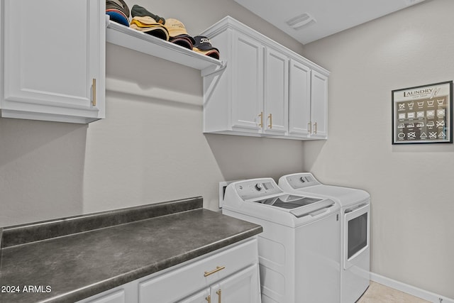 laundry area featuring cabinets, light tile patterned flooring, and washer and dryer