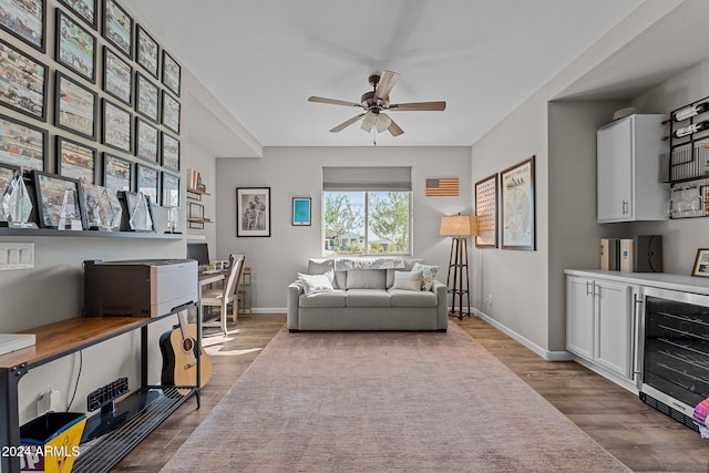 living room with light wood-type flooring, ceiling fan, and wine cooler