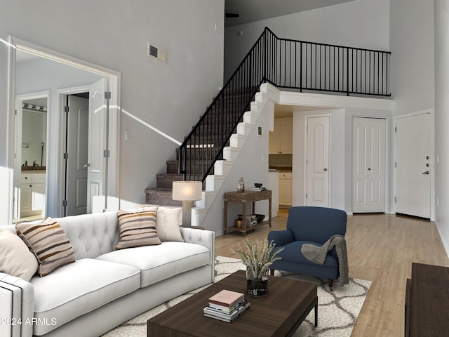 living room with a towering ceiling and light hardwood / wood-style flooring