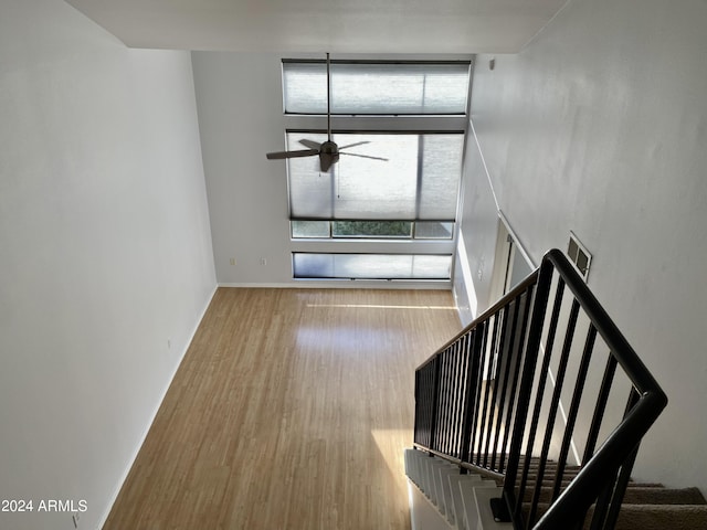 stairway featuring wood-type flooring and ceiling fan