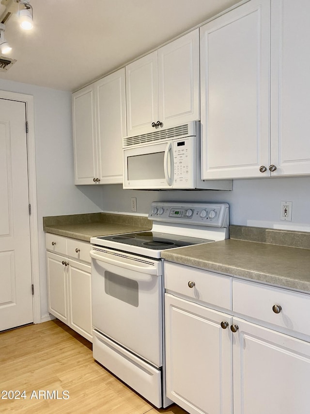 kitchen featuring white appliances, light hardwood / wood-style flooring, and white cabinets