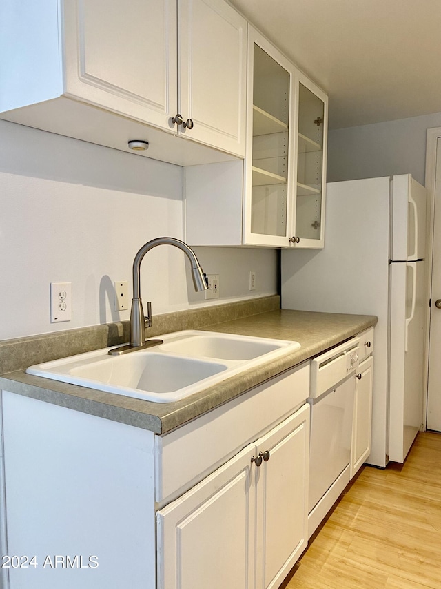 kitchen featuring dishwasher, sink, light hardwood / wood-style flooring, and white cabinets