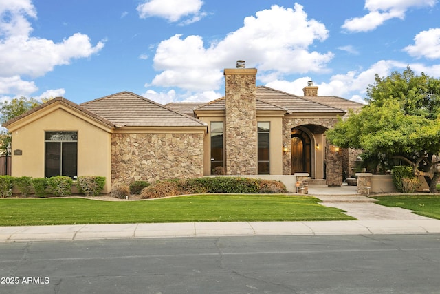 4401 E Taurus Pl, Chandler, AZ 85249 - view of front of property with a front yard, stone siding, a chimney, stucco siding, and a tiled roof