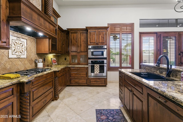 4401 E Taurus Pl, Chandler, AZ 85249 - kitchen with stainless steel appliances, a sink, custom range hood, light stone counters, and backsplash