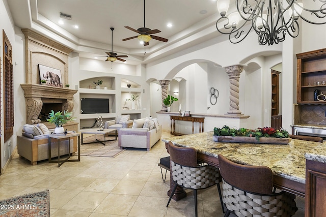 4401 E Taurus Pl, Chandler, AZ 85249 - living area featuring decorative columns, ceiling fan with notable chandelier, a raised ceiling, visible vents, and built in features