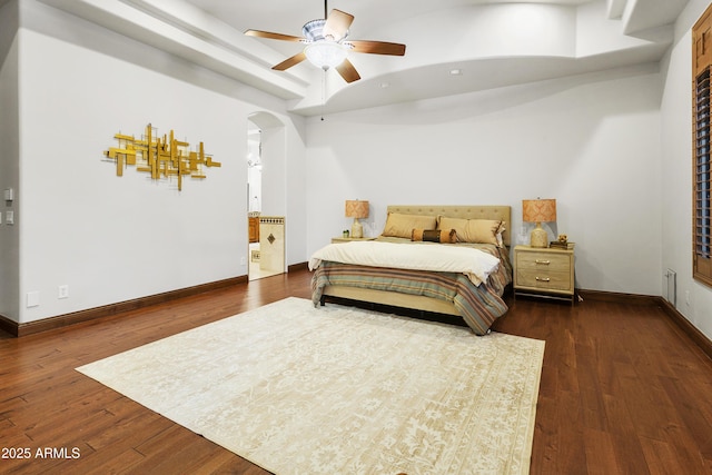 4401 E Taurus Pl, Chandler, AZ 85249 - bedroom featuring baseboards, dark wood-style flooring, arched walkways, and a raised ceiling