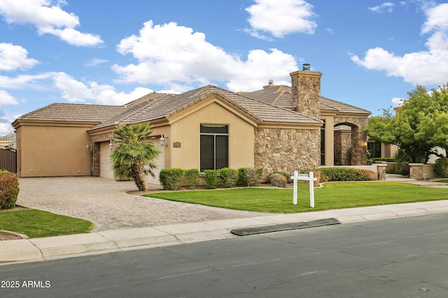 4401 E Taurus Pl, Chandler, AZ 85249 - mediterranean / spanish home with decorative driveway, a chimney, a garage, a front yard, and stucco siding