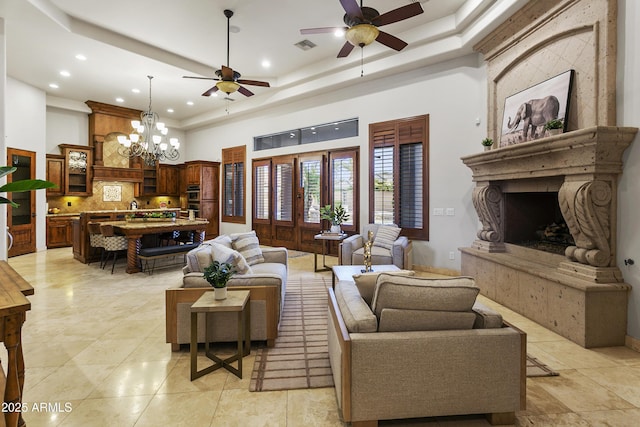 4401 E Taurus Pl, Chandler, AZ 85249 - living area with a tray ceiling, ceiling fan with notable chandelier, a towering ceiling, and a large fireplace