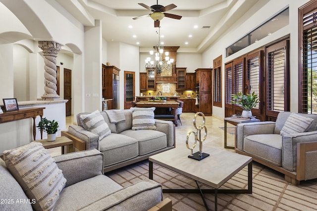 4401 E Taurus Pl, Chandler, AZ 85249 - living room featuring decorative columns, a high ceiling, ceiling fan with notable chandelier, arched walkways, and recessed lighting