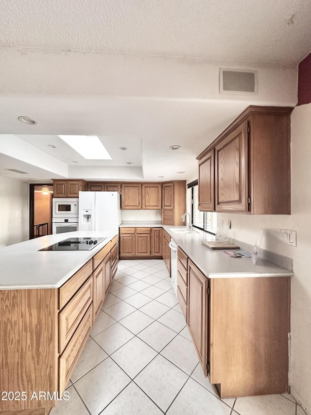 1124 N Villa Nueva Dr, Litchfield Park, AZ 85340 - kitchen featuring white appliances, a sink, light countertops, light tile patterned floors, and recessed lighting