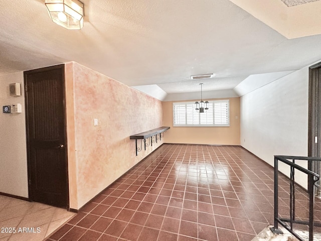 1124 N Villa Nueva Dr, Litchfield Park, AZ 85340 - spare room featuring vaulted ceiling, dark tile patterned floors, and a chandelier