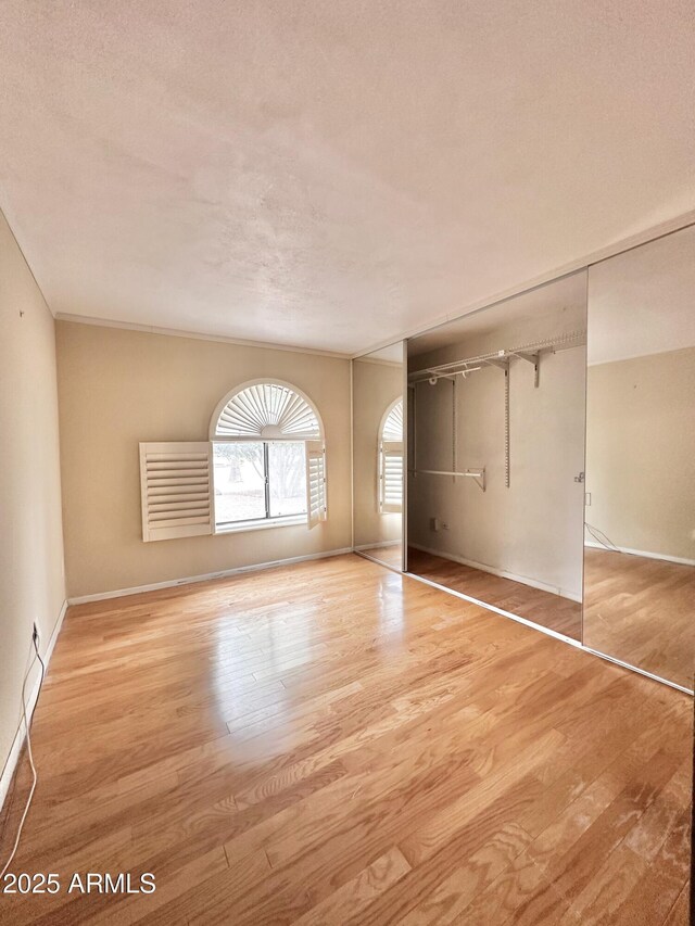 1124 N Villa Nueva Dr, Litchfield Park, AZ 85340 - empty room with wood finished floors, baseboards, and a textured ceiling