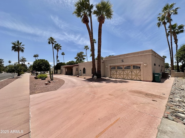 1124 N Villa Nueva Dr, Litchfield Park, AZ 85340 - view of front facade with curved driveway, an attached garage, stucco siding, and cooling unit