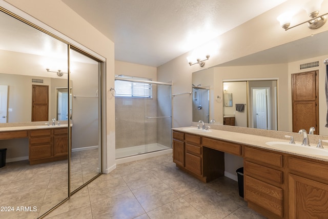 bathroom featuring tile patterned flooring, vanity, and an enclosed shower