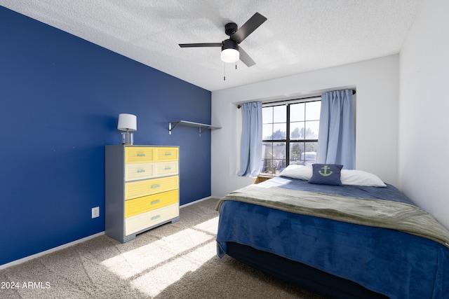 carpeted bedroom with ceiling fan and a textured ceiling