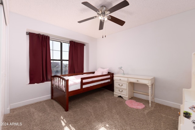 carpeted bedroom featuring ceiling fan and a textured ceiling