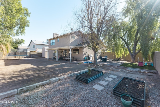 rear view of house with a patio area and a trampoline